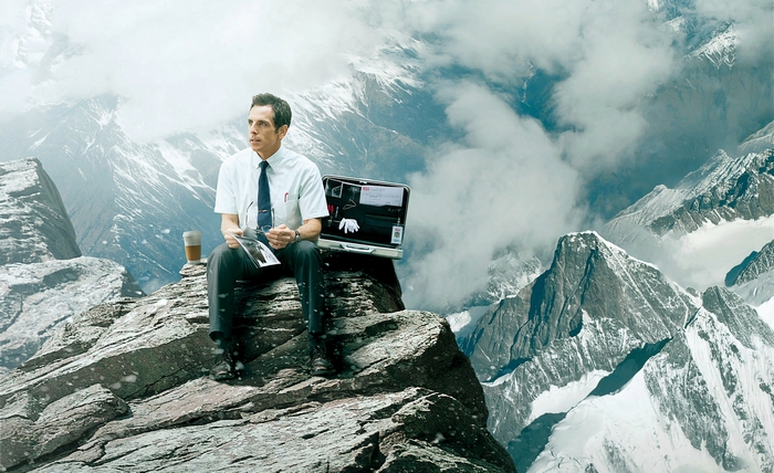 Ben Stiller sitting on a mountain peak
