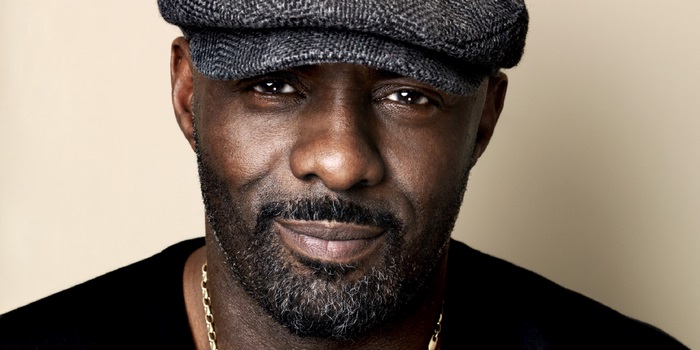 Idris Elba wearing a flat cap