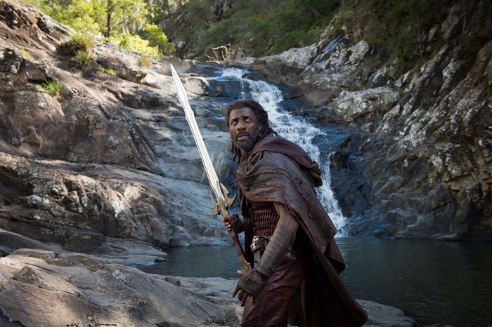 Idris Elba as Heimdall holding a sword