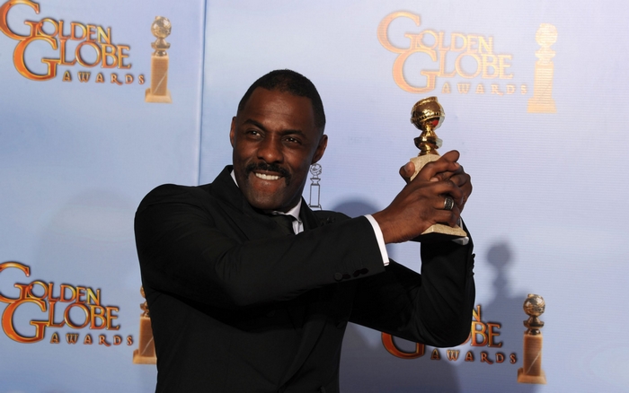 Idris Elba holding a Golden Globe Award
