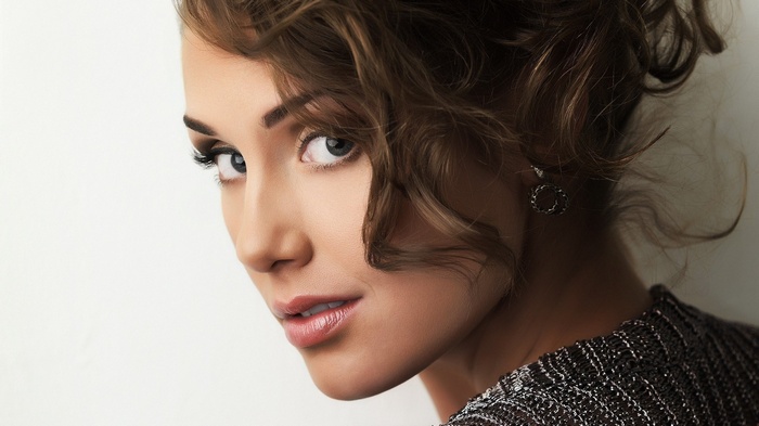 Woman with curly brown hair and earrings