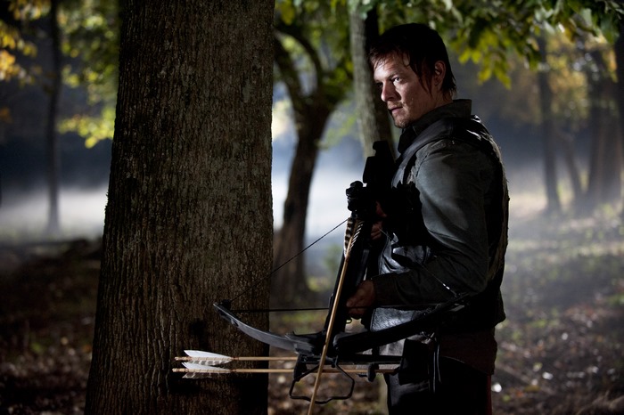 Norman Reedus with crossbow in forest