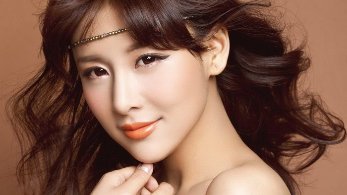 Woman with dark wavy hair and headband