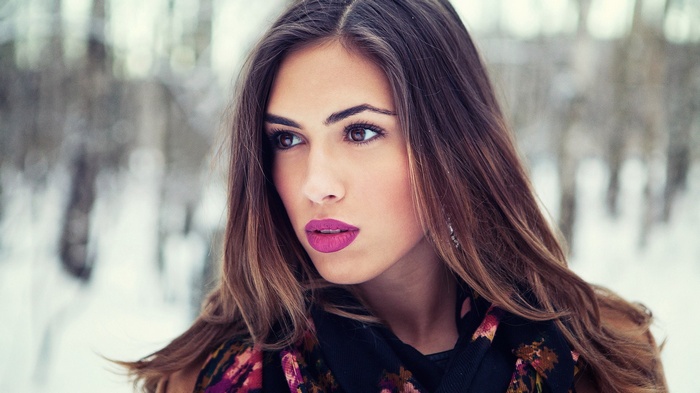 Woman with pink lipstick in winter forest