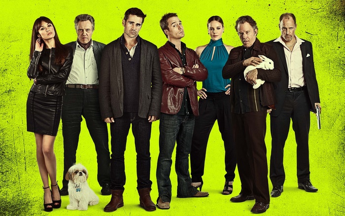 Seven People and a Dog Posed Against a Bright Green Background