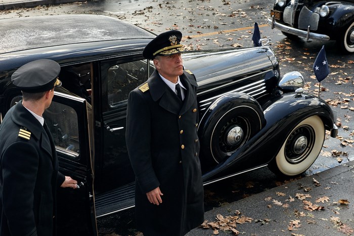 Woody Harrelson in a military uniform by a vintage car