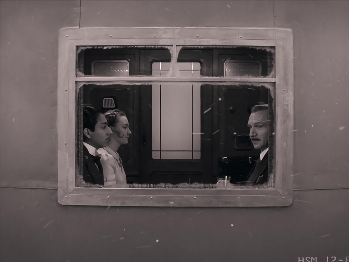 Saoirse Ronan and two men in a train compartment