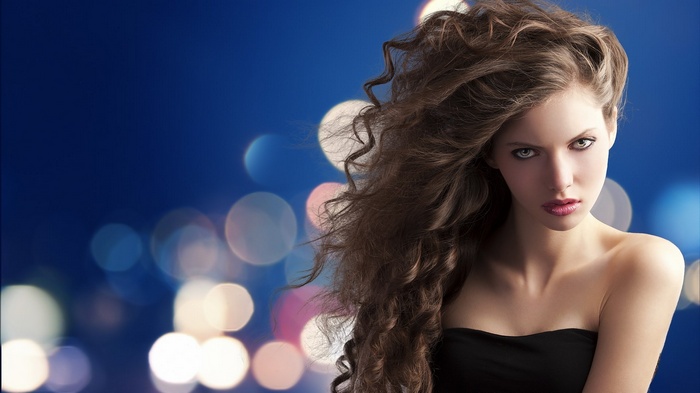Woman with long curly hair and bokeh background