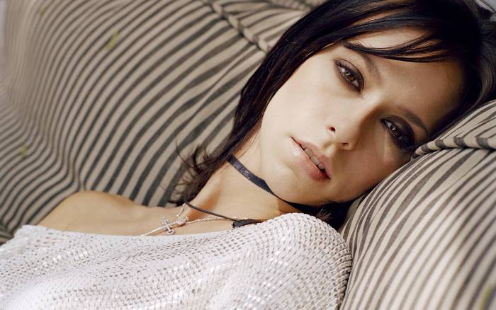 Jennifer Love Hewitt lying on a striped couch