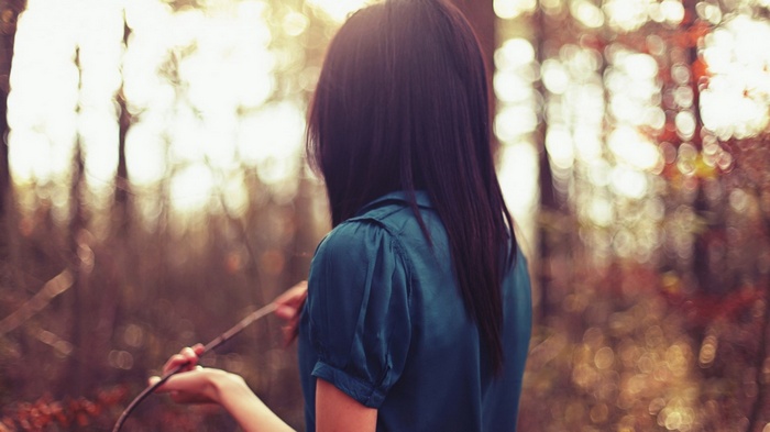 Woman holding a stick in a forest