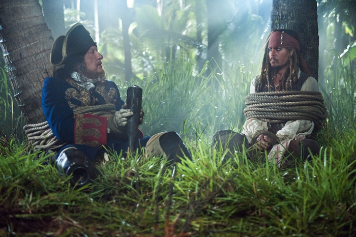Geoffrey Rush and Johnny Depp tied up in a jungle