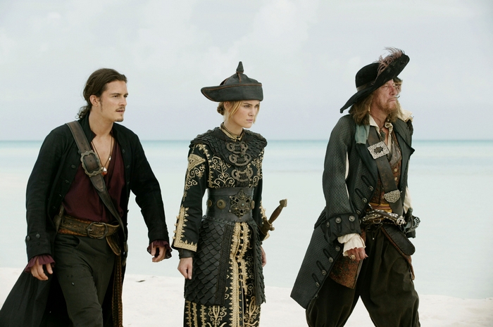 Geoffrey Rush and two other pirates on a beach