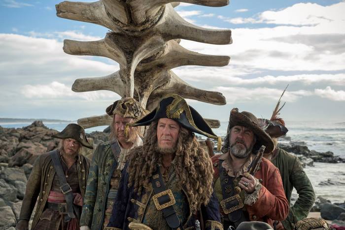 Captain Barbossa and his crew on a rocky shore