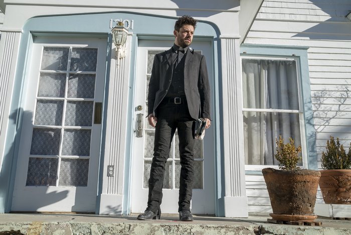 Dominic Cooper standing in front of a house