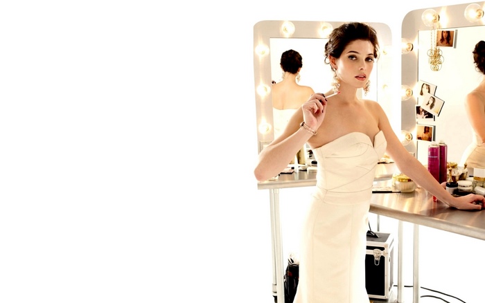 Ashley Greene in a white dress applying makeup