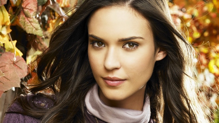 Woman with long dark hair and autumn leaves