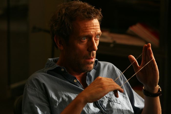 Hugh Laurie playing with a rubber band
