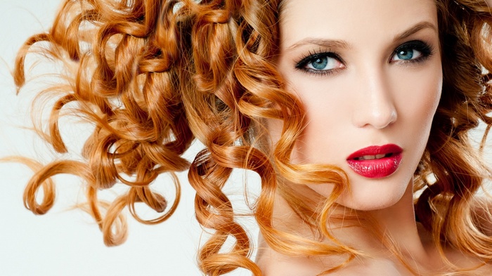 Woman with red curly hair and blue eyes