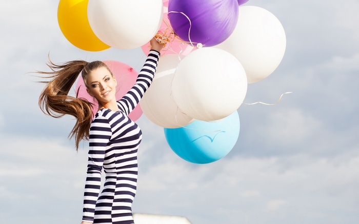 Woman holding balloons outdoors