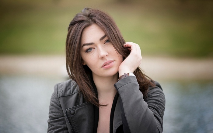 Woman in a black jacket by the water