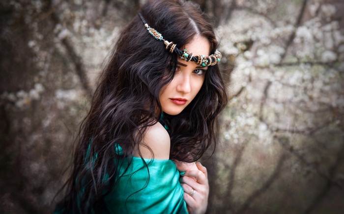 Woman with dark wavy hair and a turquoise dress