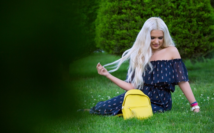 Woman with blonde hair and yellow backpack in a park