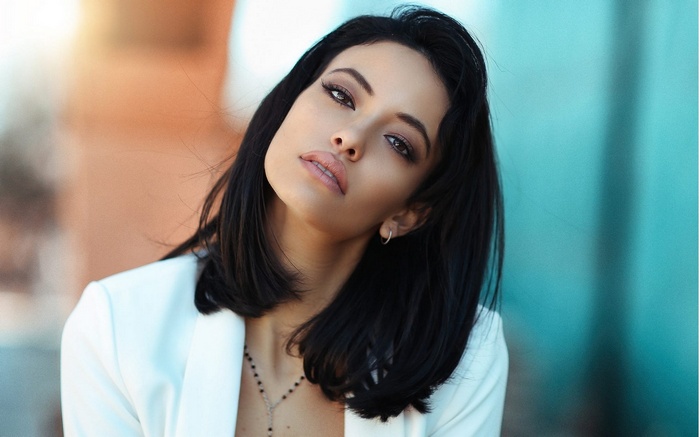 Woman in white blazer with dark hair
