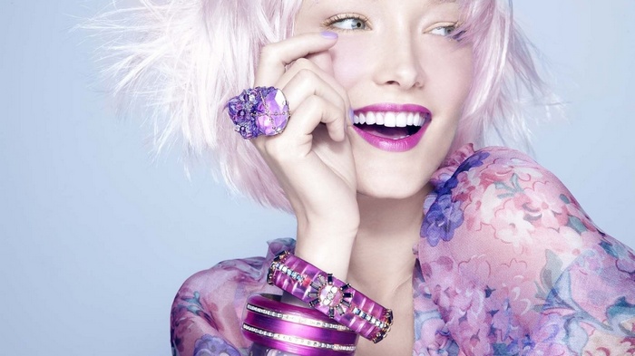 Woman with pink hair and purple jewelry