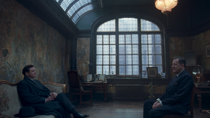 Colin Firth in a formal room