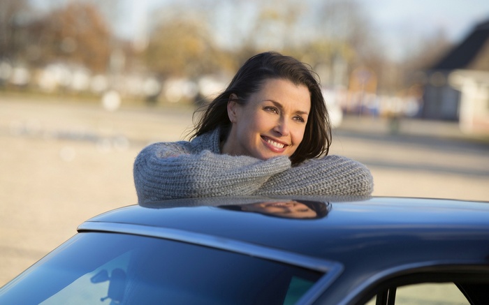 Woman leaning on a car roof