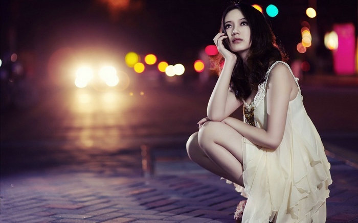 Woman on phone at night with city lights