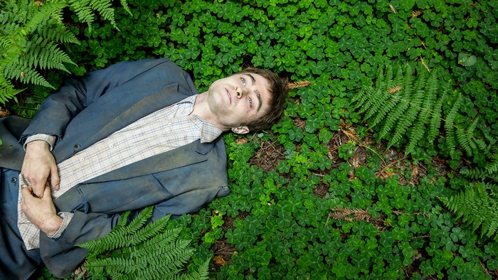 Daniel Radcliffe lying in a forest