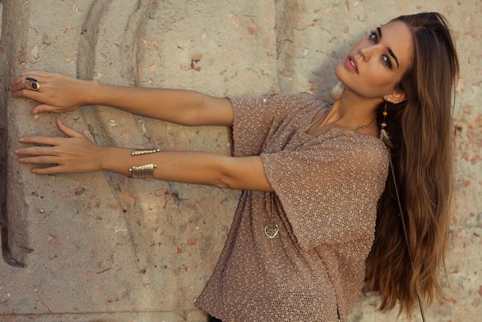 Clara Alonso leaning against a stone wall