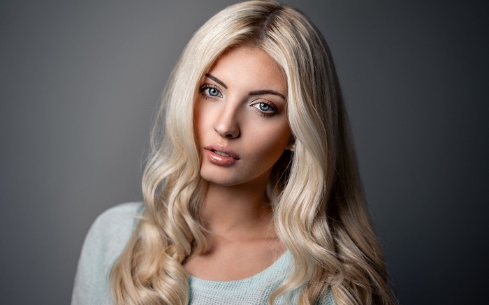 Woman with blonde wavy hair and blue eyes