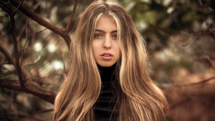 Woman with long blonde hair in a black turtleneck