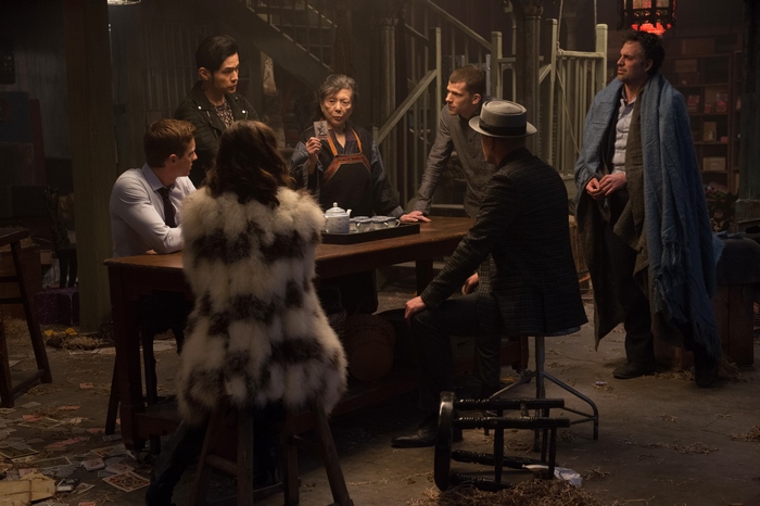 Jesse Eisenberg and group in a dimly lit room