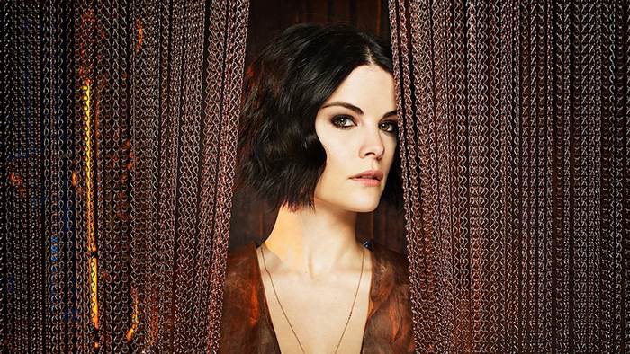 Jaimie Alexander behind chain curtain