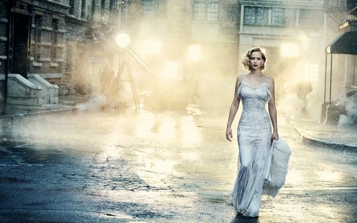 Jennifer Lawrence in a white dress walking in the rain