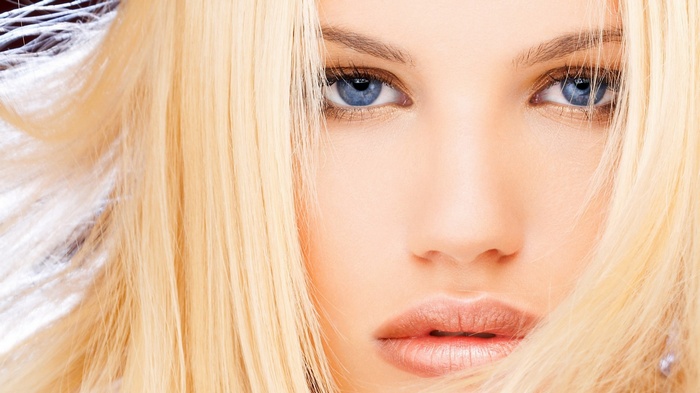 Close-up of a blonde woman's face with blue eyes