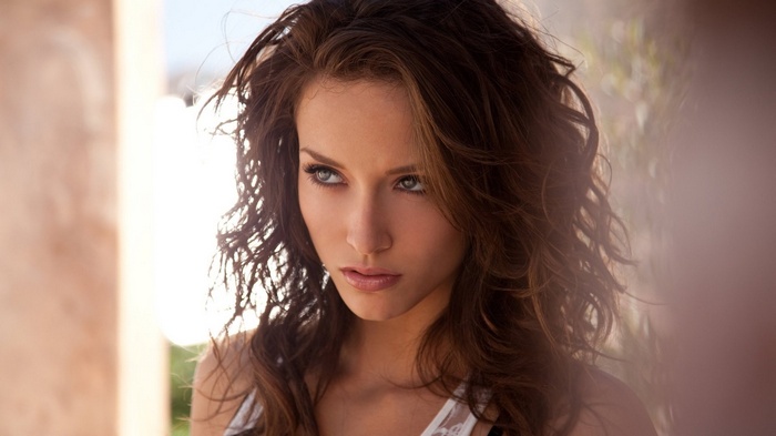 Woman with brown curly hair looking to the side