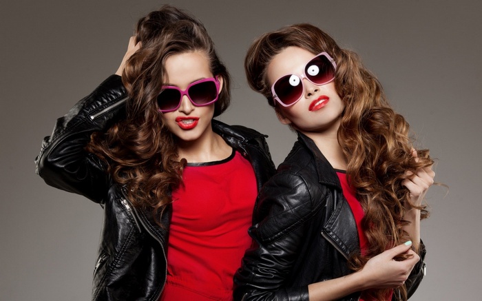 Two young women wearing sunglasses and leather jackets