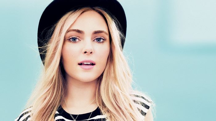 AnnaSophia Robb wearing a black hat and striped shirt