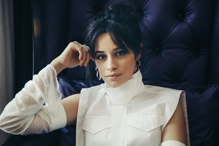 Camila Cabello sitting in a chair