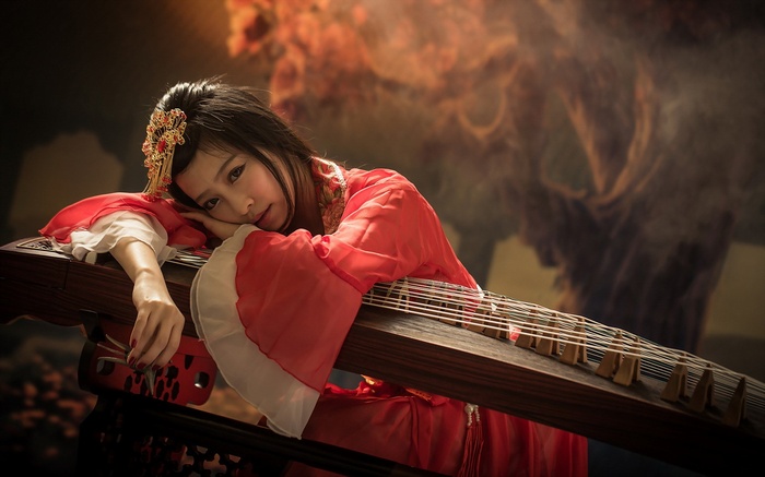 Woman in red dress with traditional Chinese instrument