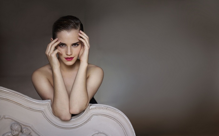 Emma Watson posing on a chaise lounge