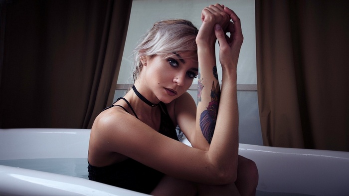 Woman in bathtub with tattoos
