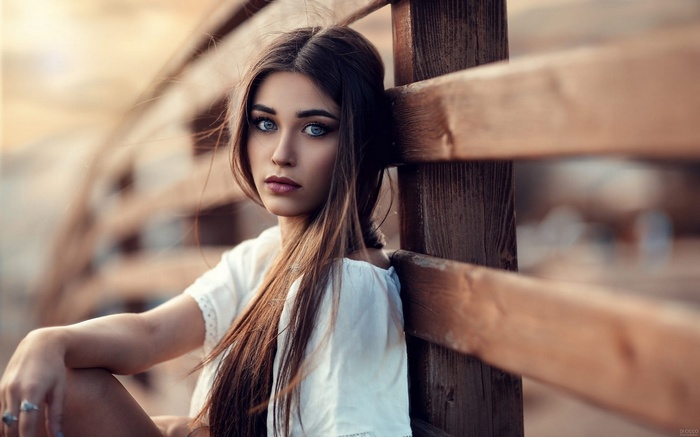 Woman leaning on a wooden fence