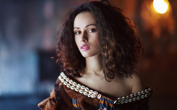 Woman with curly hair and shell necklace