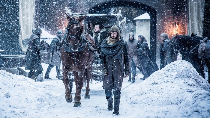 Man walking with horse-drawn carriage in snow