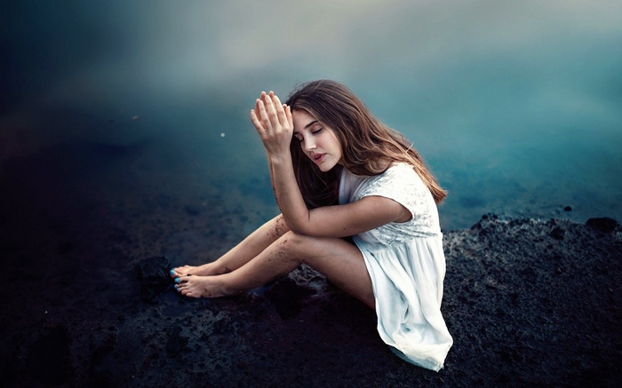 Woman sitting by the water